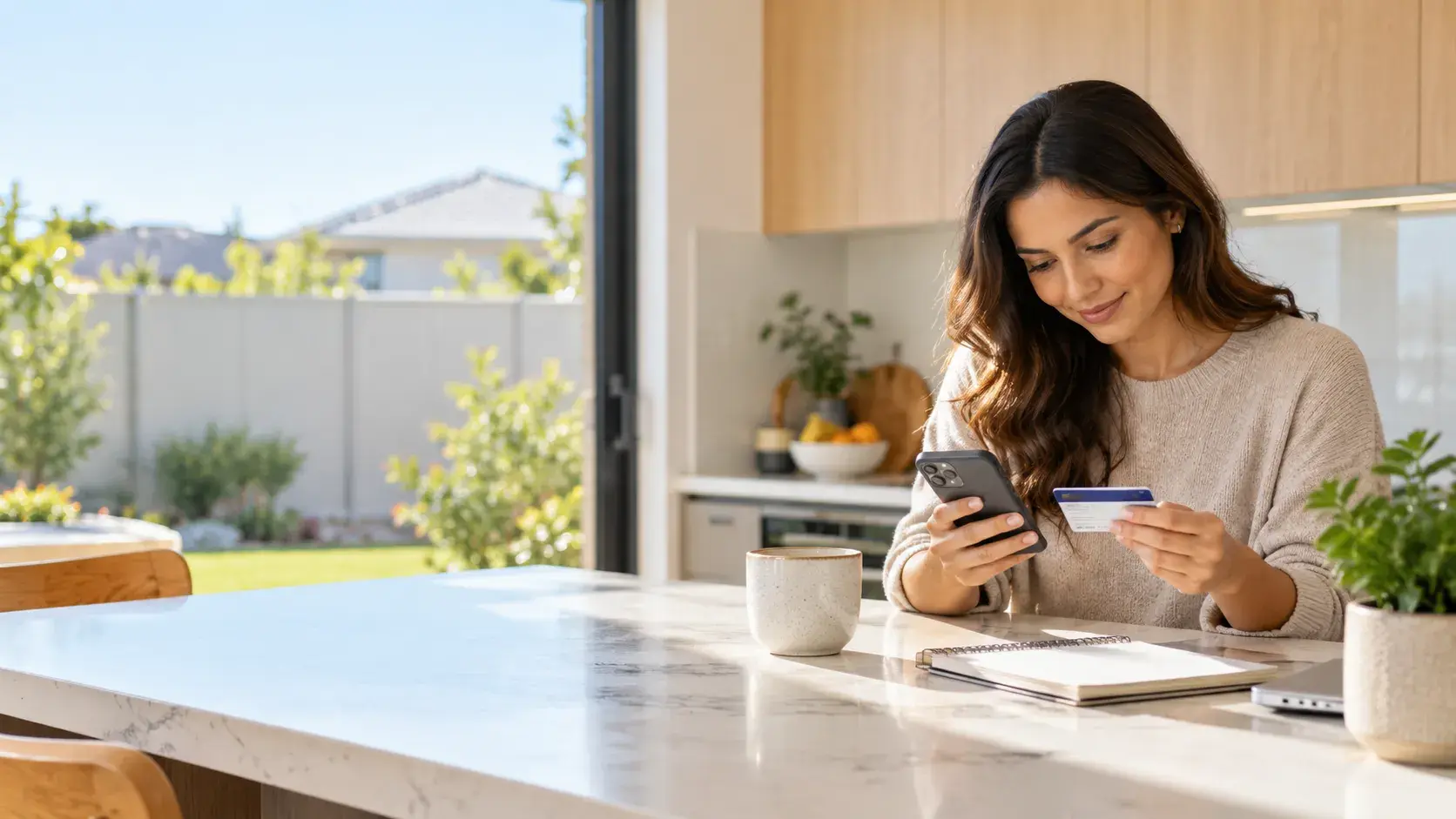 A kitchen bench in a new Wanneroo-area home with a phone, a health fund card and a coffee cup in morning light.